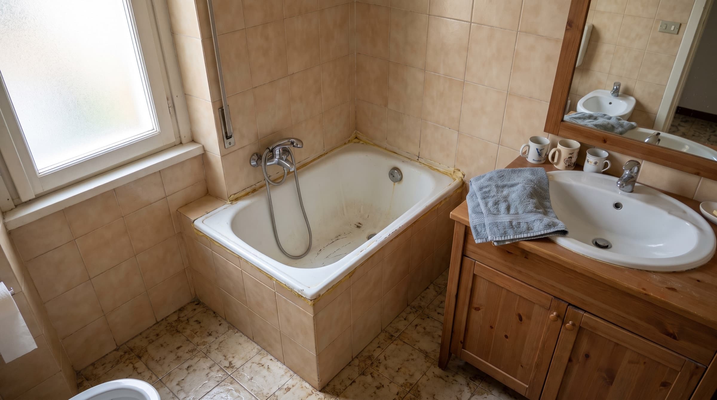 Vecchia vasca da bagno incassata in un bagno anni '80