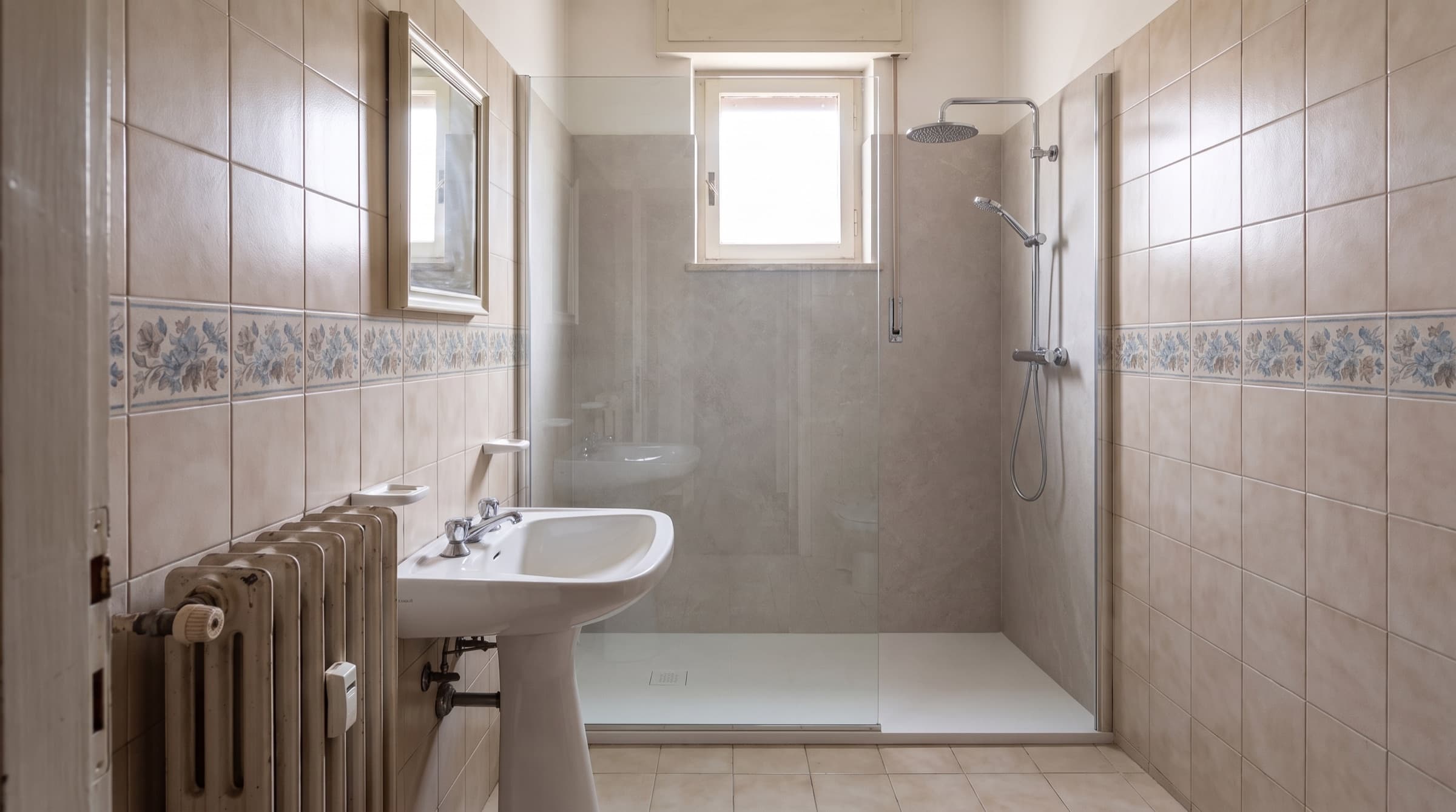 Lo stesso bagno dopo la trasformazione: doccia walk-in al posto della vasca
