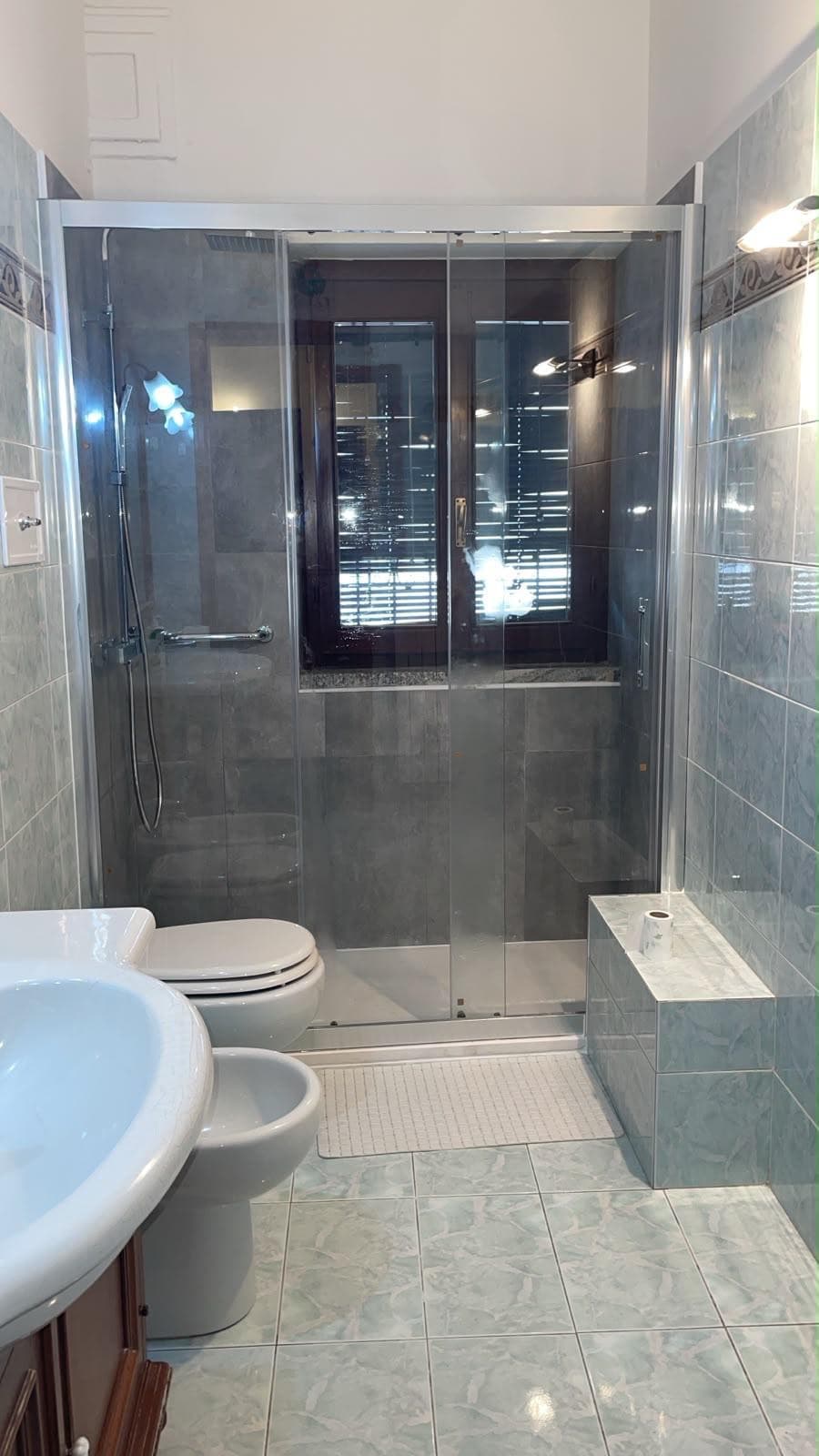 Doccia in nicchia con finestra e box scorrevole in cristallo