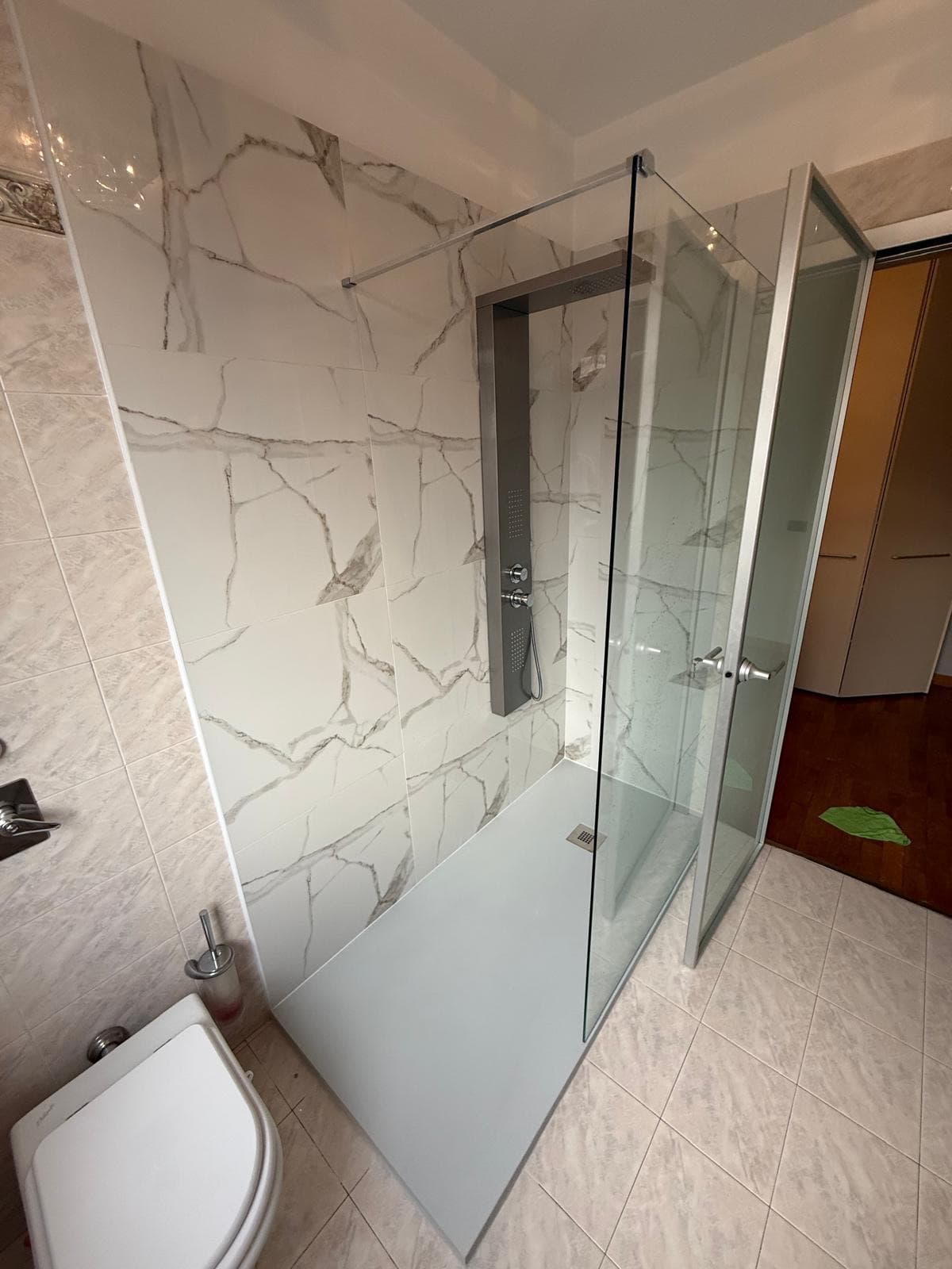 Doccia walk-in con pareti effetto marmo e piatto doccia grigio